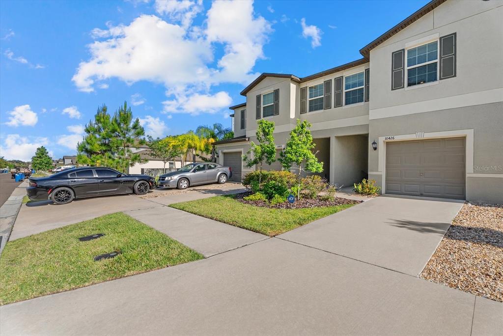 A two-story townhouse exterior features a concrete driveway, a garage, and a small front yard — 10426 SHADY PRESERVE DRIVE, RIVERVIEW, FL