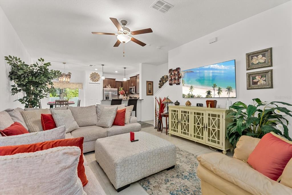 A living room features a large sectional sofa, a patterned ottoman, and a media console — 10426 SHADY PRESERVE DRIVE, RIVERVIEW, FL