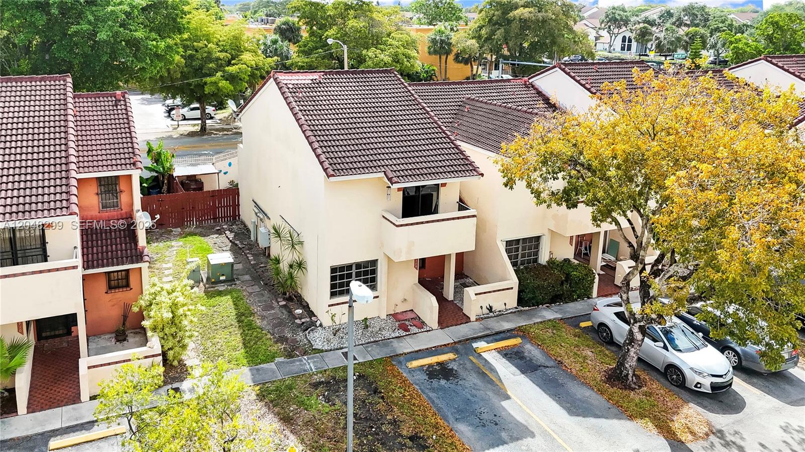 A two-story stucco townhouse features a red tile roof and a small second-floor balcony — 17908 NW 68th Ave # 5, Hialeah FL 33015, HIALEAH, FL