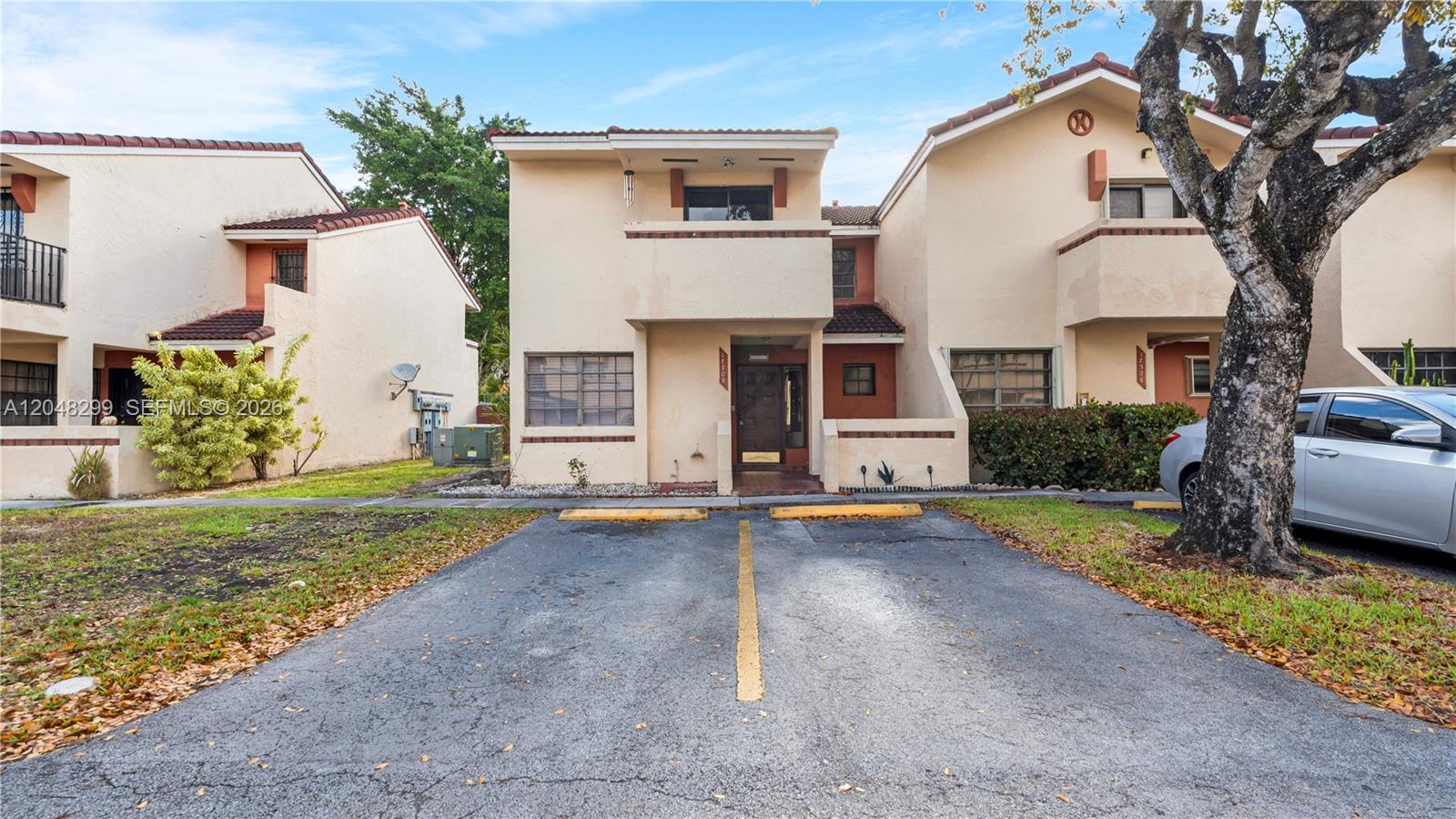 A two-story stucco townhouse features a balcony, a front entrance, and a large tree — 17908 NW 68th Ave # 5, Hialeah FL 33015, HIALEAH, FL