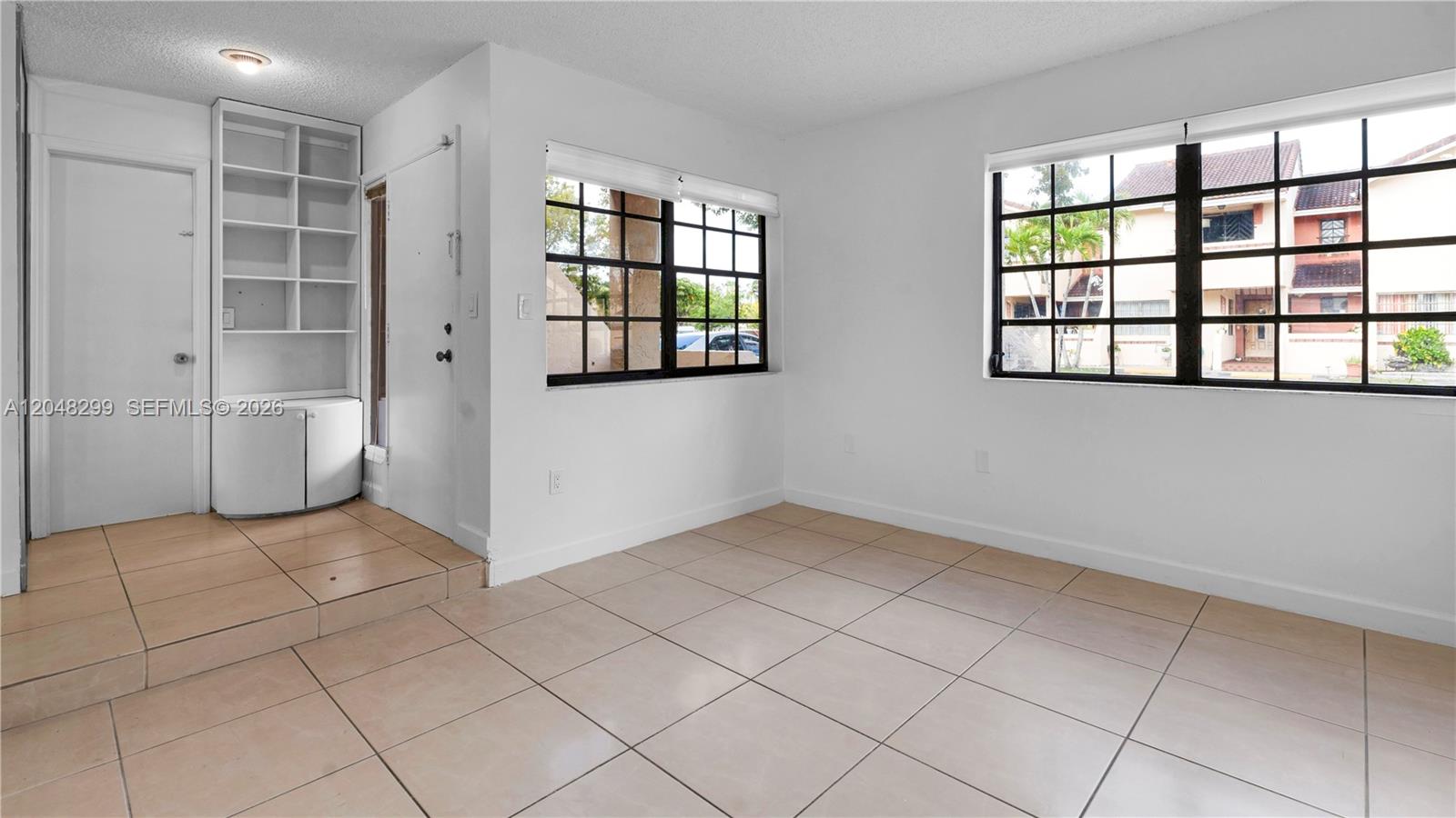 An interior room features white walls, tile flooring, a ceiling light fixture, and a shelving unit — 17908 NW 68th Ave # 5, Hialeah FL 33015, HIALEAH, FL
