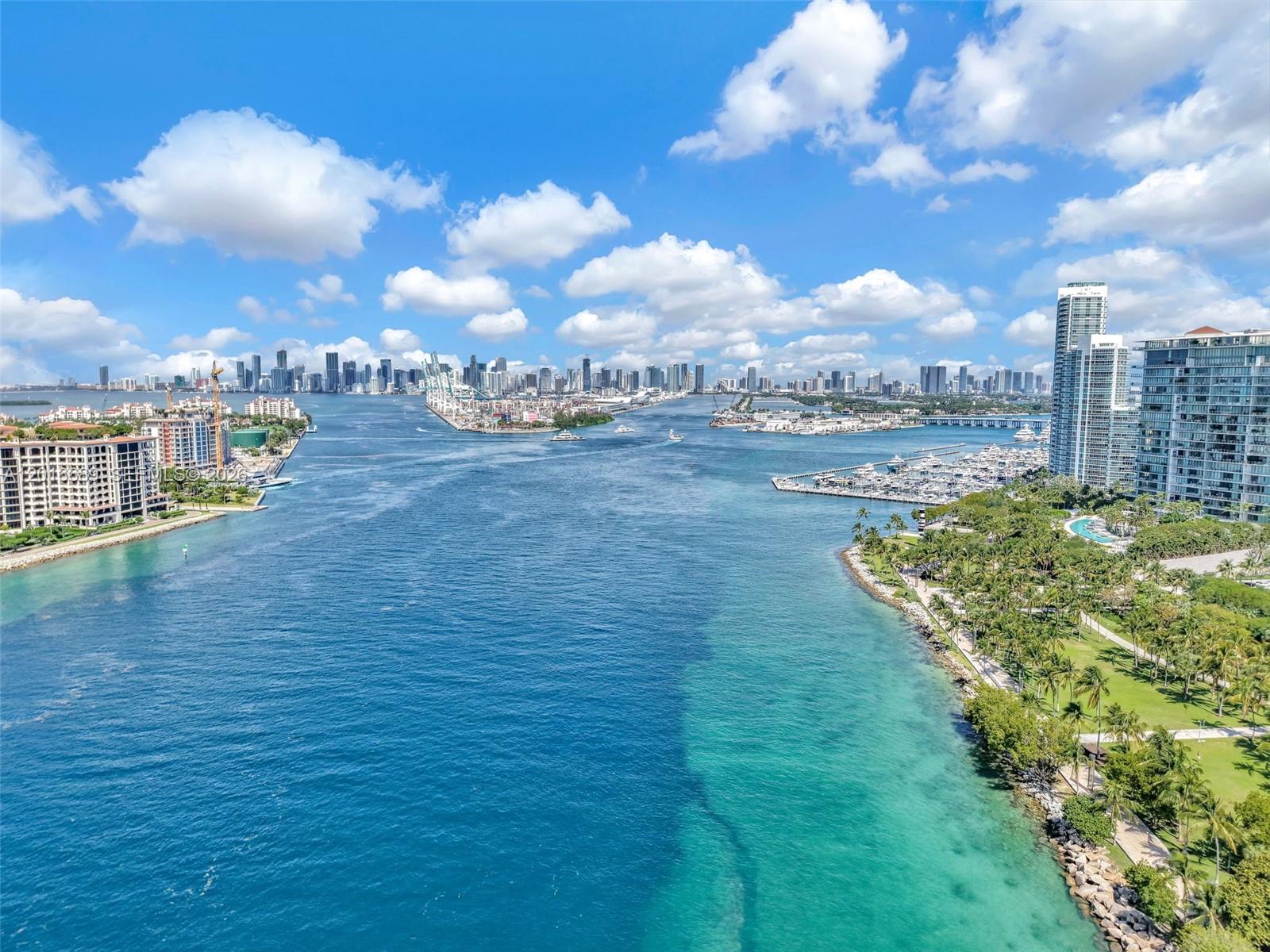 An aerial view of a waterway leading to a city skyline with buildings and trees — 100 S Pointe Dr # 801, Miami Beach FL 33139, MIAMI BEACH, FL