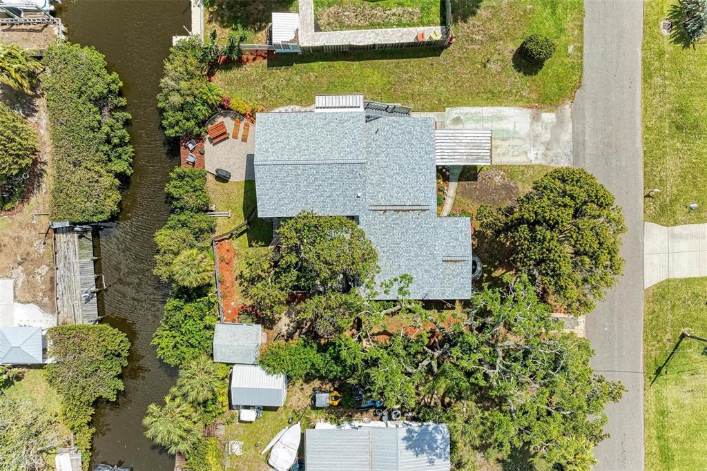 An aerial view shows a house with a gray roof, a canal, and surrounding trees — 4518 7TH STREET COURT E, ELLENTON, FL