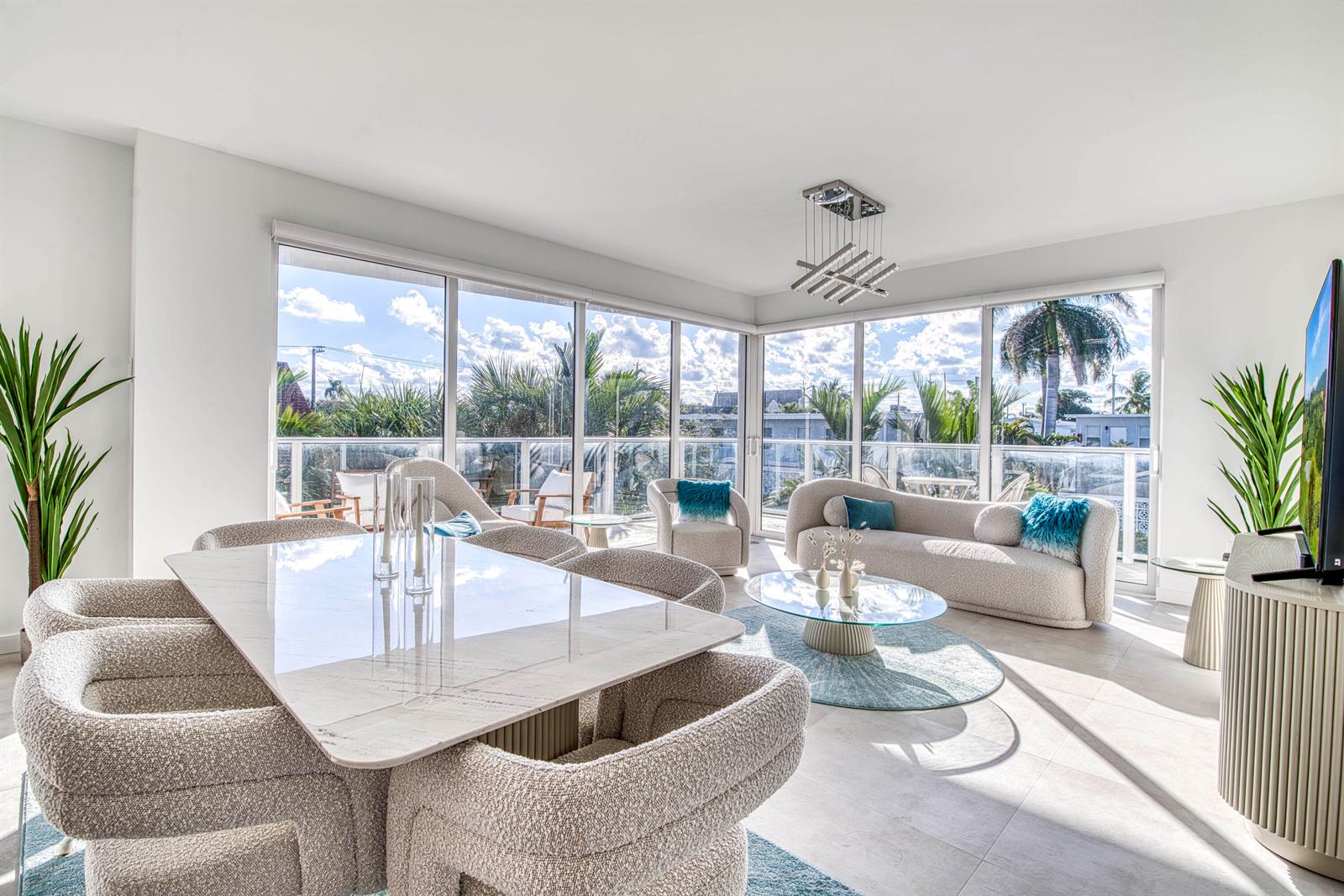 A bright, open-concept living and dining area features modern furniture, floor-to-ceiling windows, and balcony views — 117 Lake Avenue # 204, FL 33460, FL
