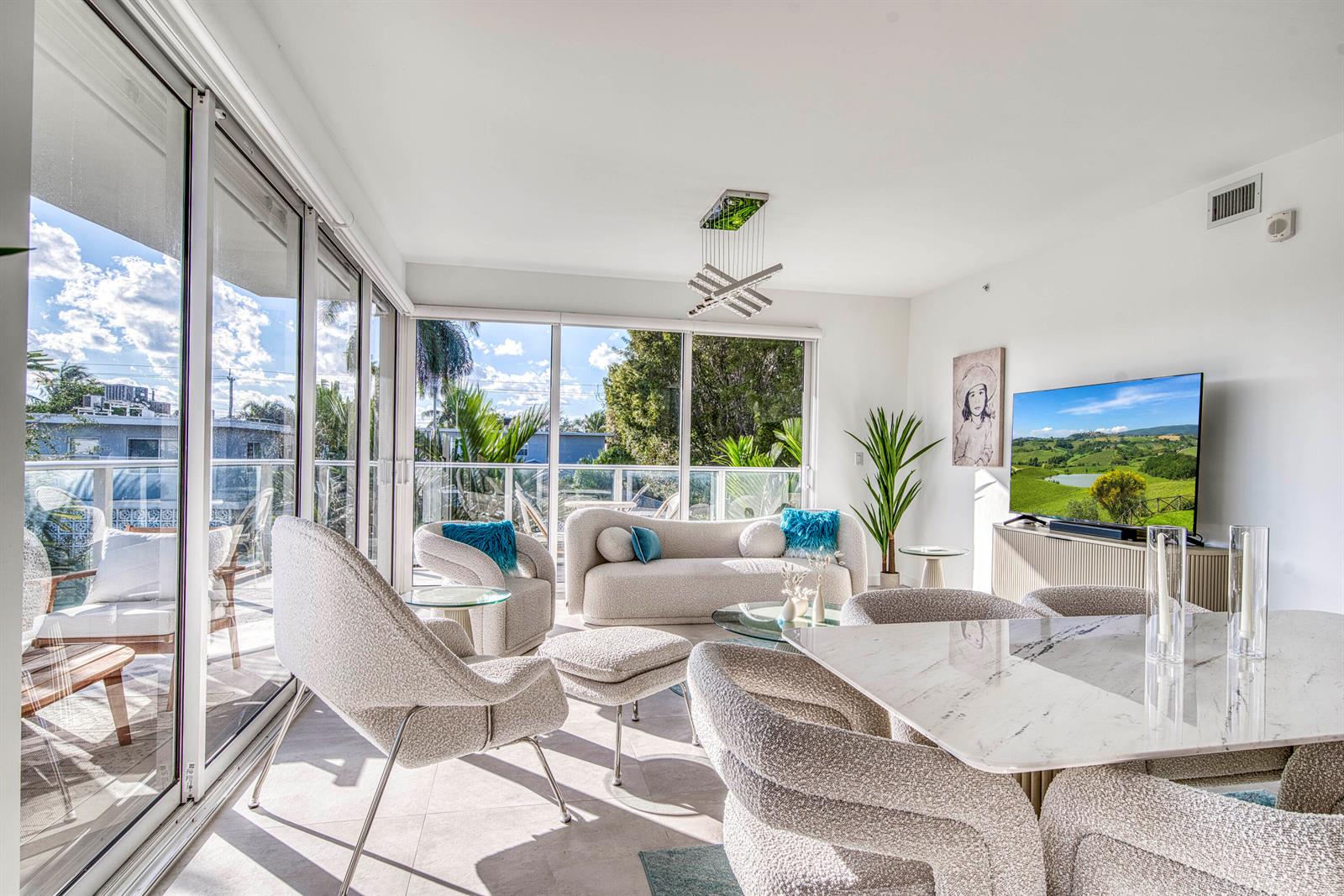 A bright living and dining area features modern furniture, floor-to-ceiling windows, and a balcony view — 117 Lake Avenue # 204, FL 33460, FL