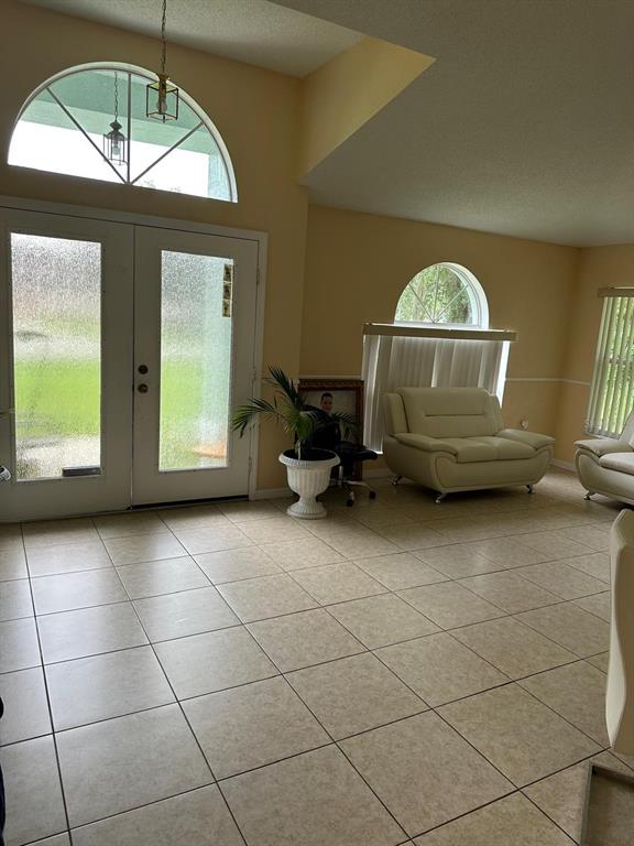 A bright entryway features tiled floors, a double front door, and a large arched window — 441 CARDINAL COURT, POINCIANA, FL