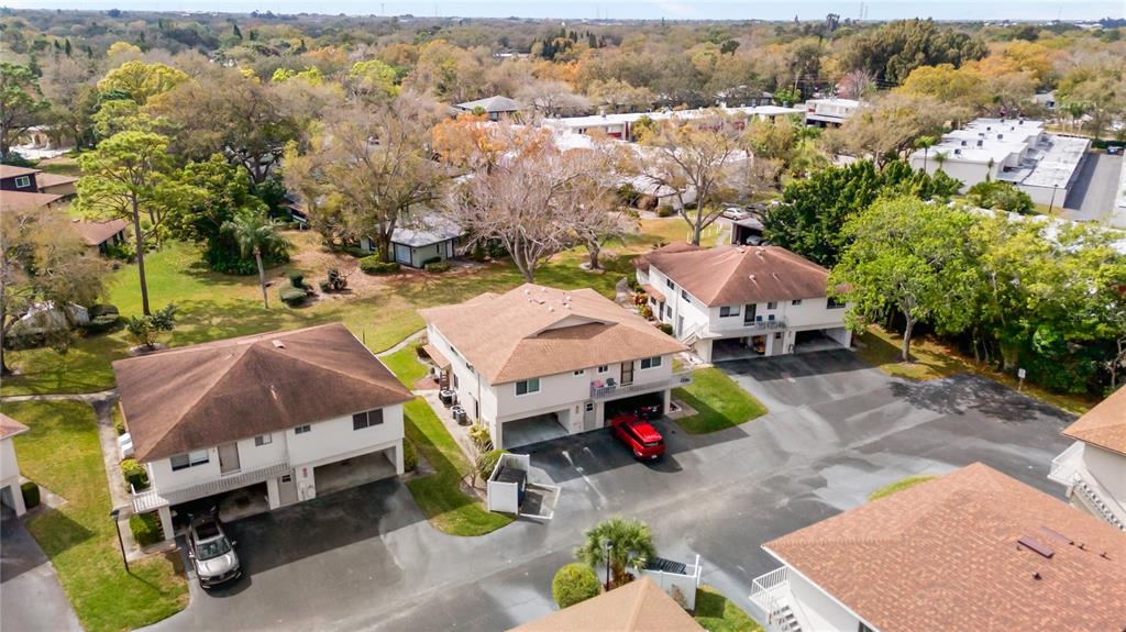 An aerial view shows several multi-story residential buildings with brown roofs and adjacent parking lots — 1832 BOUGH AVENUE UNIT 3, CLEARWATER, FL
