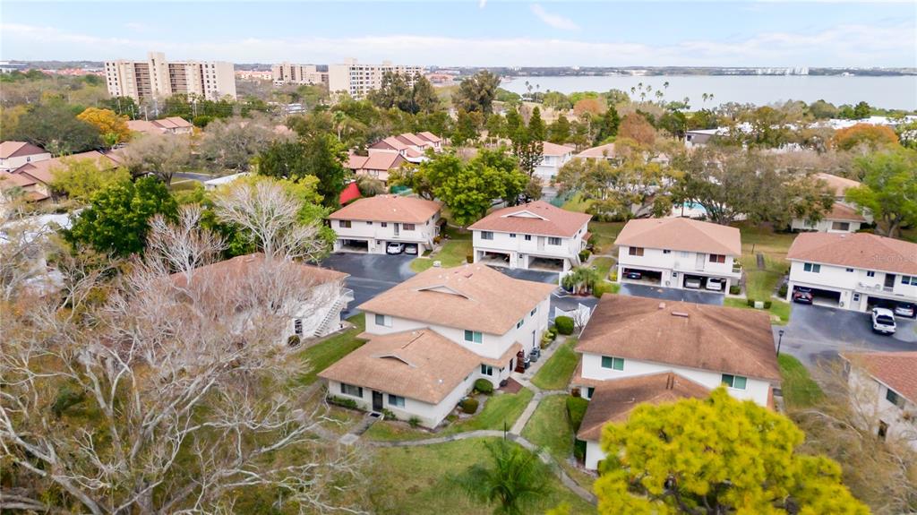 An aerial view of multi-story residential townhouses with brown roofs surrounded by trees and grass — 1832 BOUGH AVENUE UNIT 3, CLEARWATER, FL