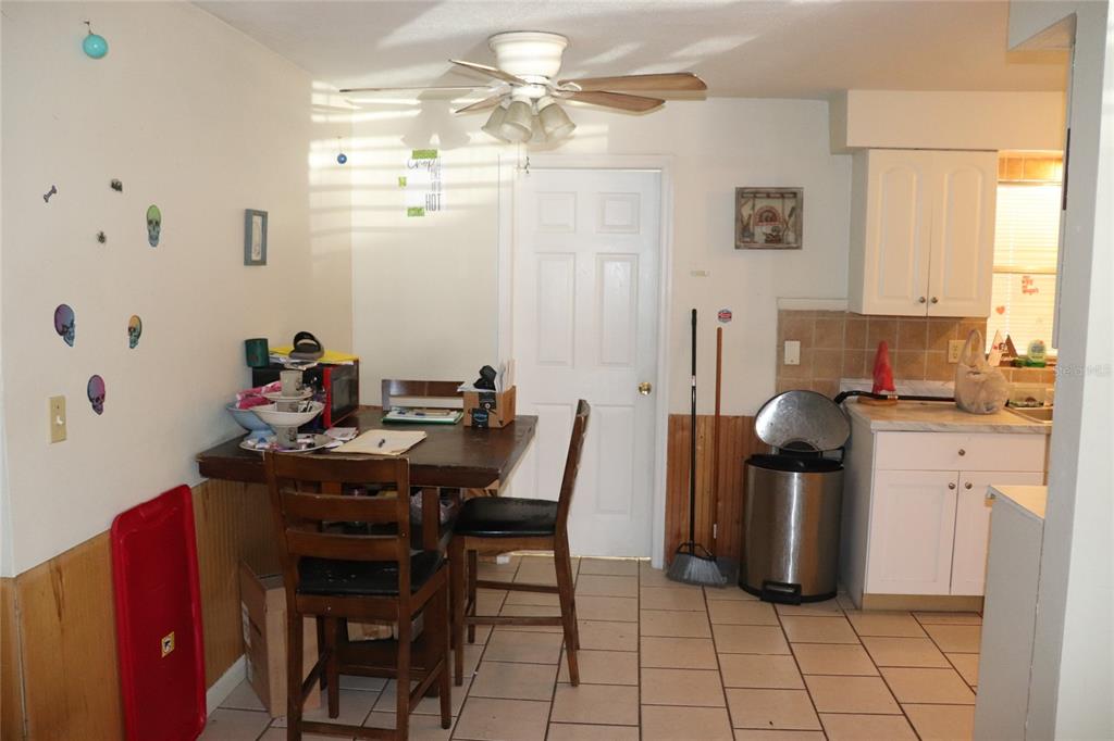 A kitchen with a dining table, tile flooring, white cabinets, and a ceiling fan — 16 S HARRISON STREET, BEVERLY HILLS, FL