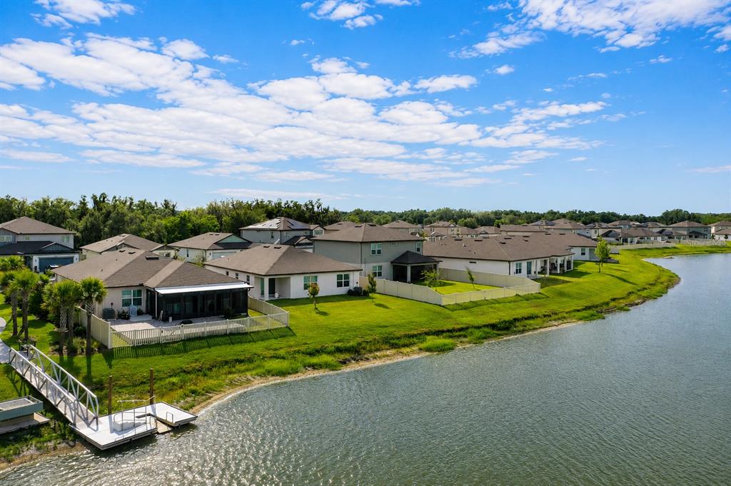 An aerial view of suburban houses with fenced backyards situated along a lake — 3830 CAPRI COAST DRIVE, PLANT CITY, FL