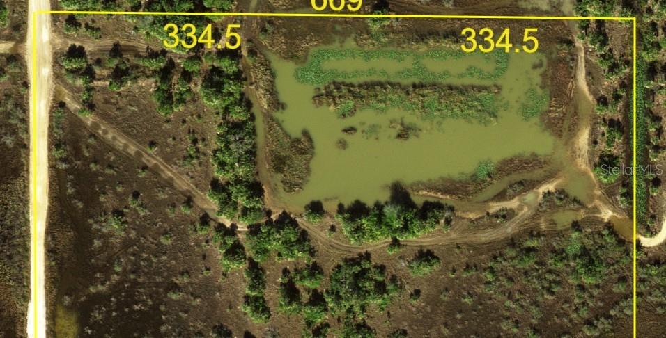 This aerial map shows a rectangular plot of land featuring a large pond and vegetation — 50690 BERMONT ROAD, PUNTA GORDA, FL
