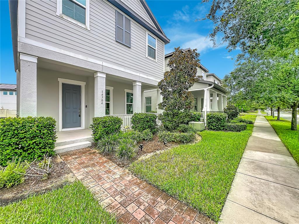 A two-story house with gray siding, a brick walkway, and a front porch — 14704 SETON CREEK BOULEVARD, WINTER GARDEN, FL