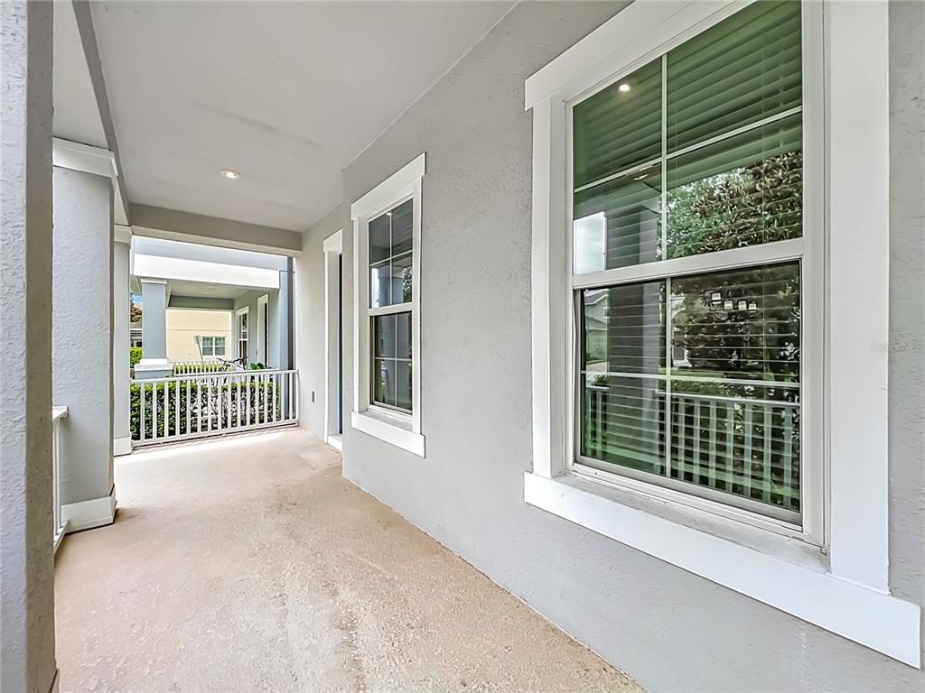 A covered outdoor porch features light gray walls, white trim, and a white railing — 14704 SETON CREEK BOULEVARD, WINTER GARDEN, FL