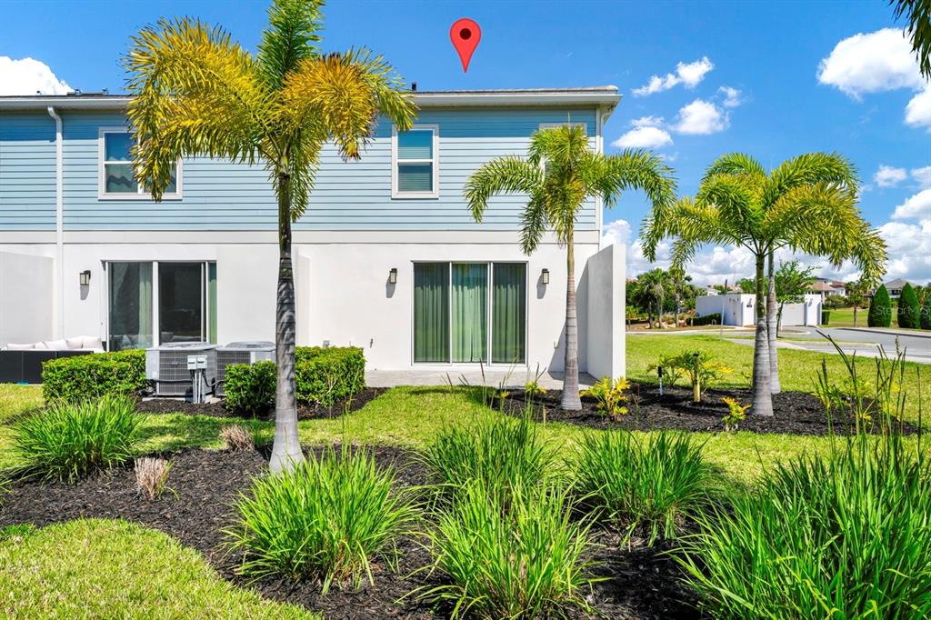 The exterior of a two-story light blue townhouse features a patio and palm trees — 743 DRIVING RANGE COURT, REUNION, FL