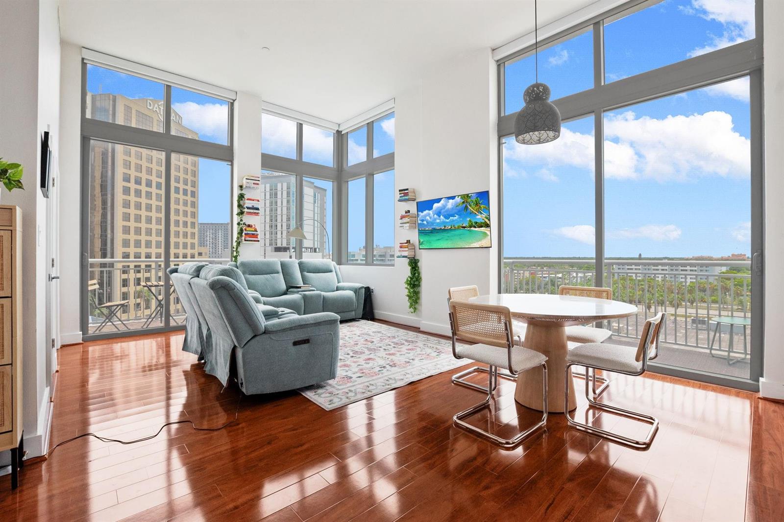 A bright living and dining area with hardwood floors, floor-to-ceiling windows, and a balcony — 9066 SW 73rd Court # 701, Miami FL 33156, MIAMI, FL