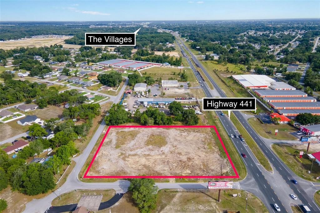 An aerial view shows a vacant, rectangular lot bordered by a highway and trees — US HWY 441/9520 SE 156TH PL, SUMMERFIELD, FL