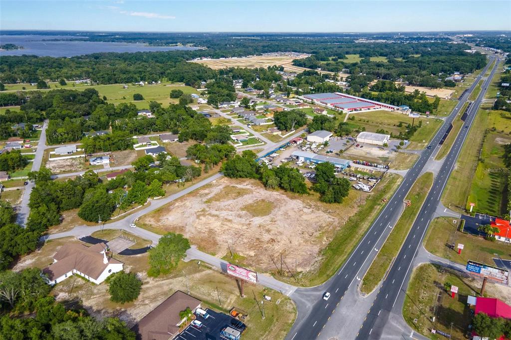 An aerial view shows a cleared, vacant lot situated next to a highway and residential area — US HWY 441/9520 SE 156TH PL, SUMMERFIELD, FL