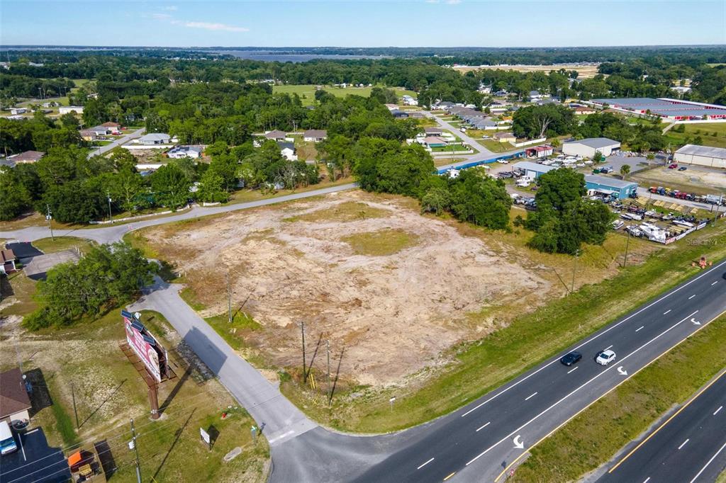 An aerial view shows a cleared, vacant lot situated between a highway and local roads — US HWY 441/9520 SE 156TH PL, SUMMERFIELD, FL