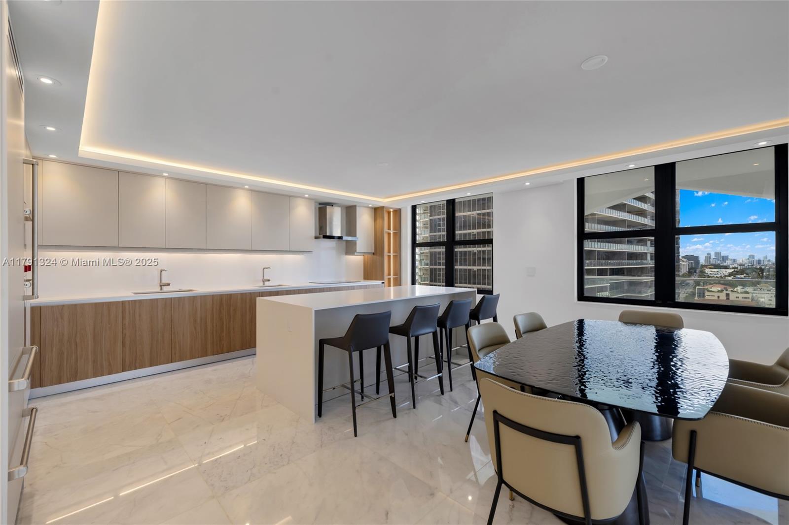A modern kitchen and dining area features marble floors, wood cabinetry, and a large island — 9801 Collins Ave # 17R, Bal Harbour FL 33154, BAL HARBOUR, FL