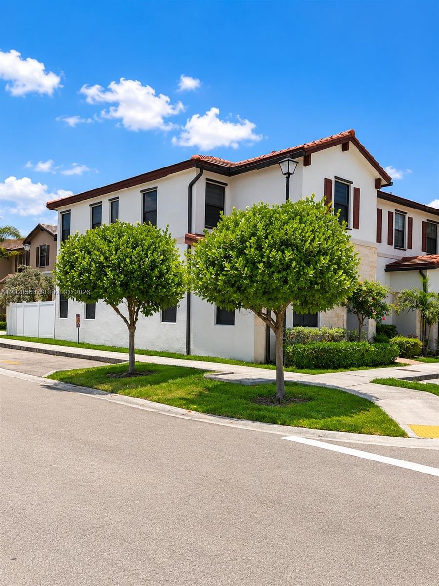 A two-story white stucco townhouse with brown shutters and two manicured trees in front — 3368 W 105th Ter, Hialeah FL 33018, HIALEAH, FL
