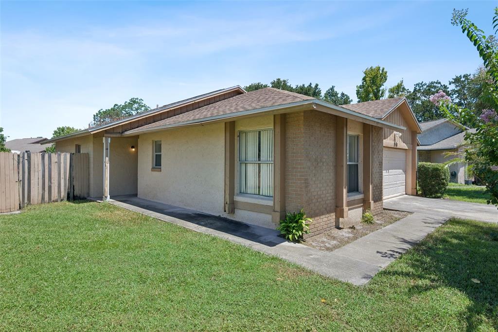 A single-story house with a stucco and brick exterior, a driveway, and a wooden fence — 2163 DILL DRIVE, ORLANDO, FL