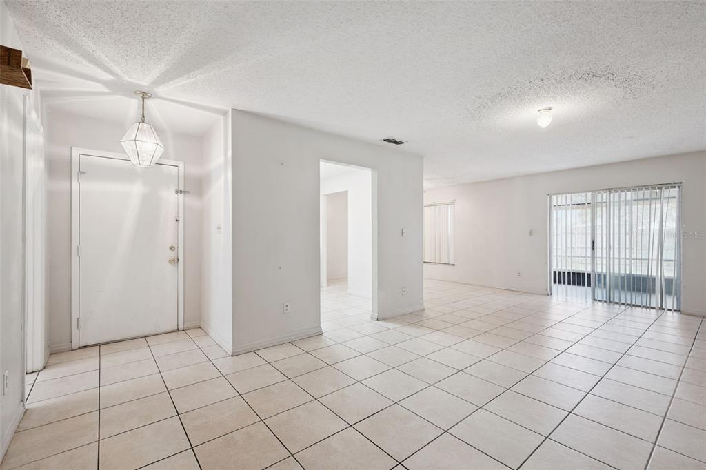 A bright, tiled entryway leads into an open living area with a sliding glass door — 2163 DILL DRIVE, ORLANDO, FL
