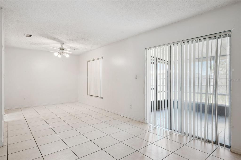 A bright room with white tile floors, a ceiling fan, and sliding glass patio doors — 2163 DILL DRIVE, ORLANDO, FL