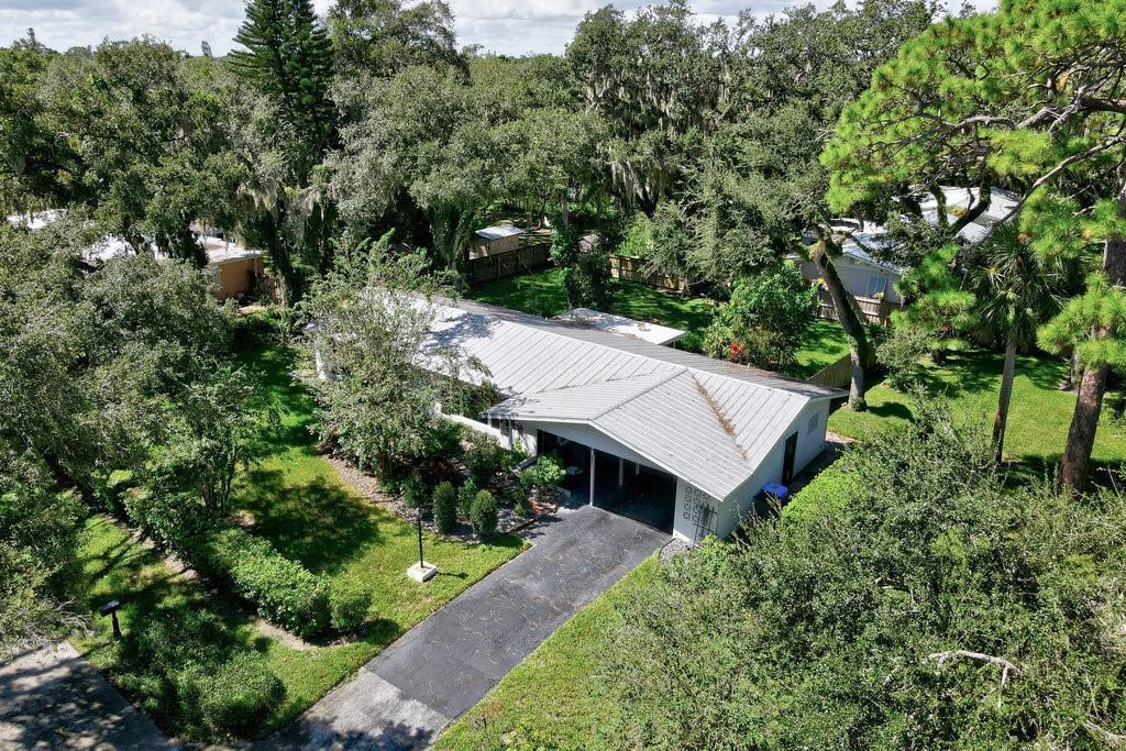 An aerial view shows a single-story house with a metal roof and an attached carport — 2811 10th Avenue, Vero Beach FL 32960, VERO BEACH, FL