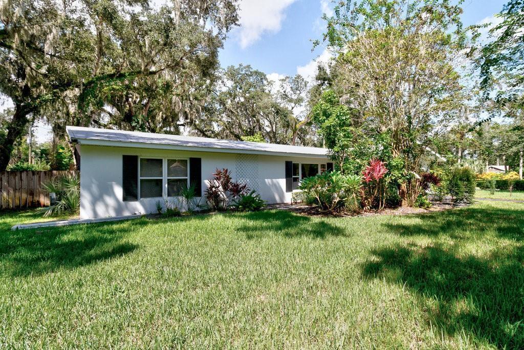 A single-story white house with black shutters sits behind a large, grassy front yard — 2811 10th Avenue, Vero Beach FL 32960, VERO BEACH, FL