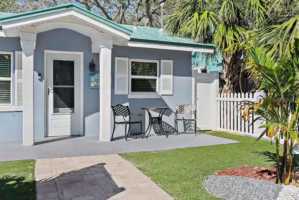 A small blue house features a front porch with a table and two chairs — 724 GULF BOULEVARD, INDIAN ROCKS BEACH, FL