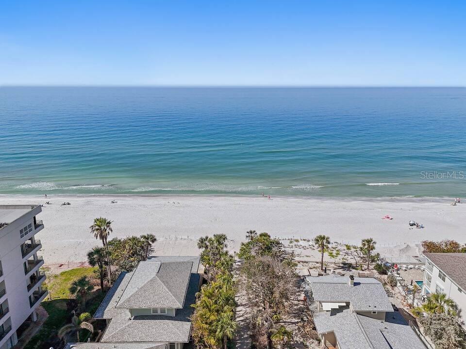 An aerial view of a sandy beach and oceanfront homes under a clear blue sky — 724 GULF BOULEVARD, INDIAN ROCKS BEACH, FL