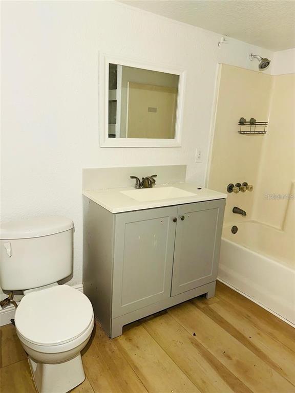 A bathroom features a gray vanity, a white toilet, and a shower-tub combination — 10221 BEAM STREET, JACKSONVILLE, FL