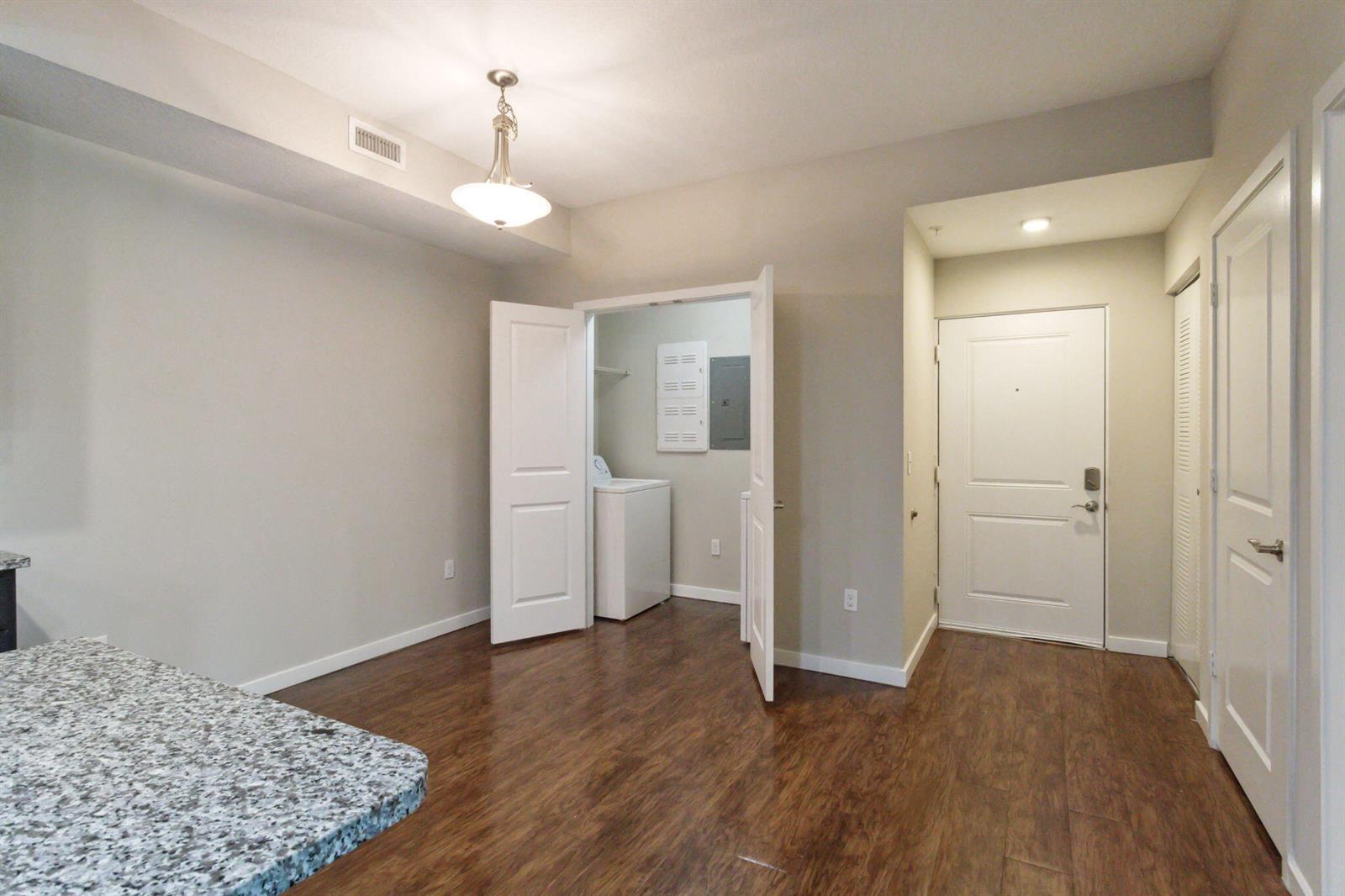 An interior view showing a room with wood-look flooring, a laundry closet, and an entryway — 3617 High Ridge Way # 206, Boynton Beach FL 33426, BOYNTON BEACH, FL
