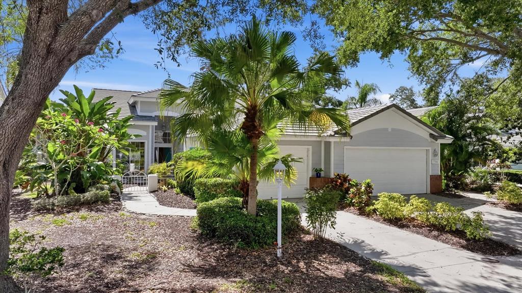 A single-story house with a two-car garage, palm trees, and a landscaped front yard — 7706 WHITEBRIDGE GLEN, UNIVERSITY PARK, FL
