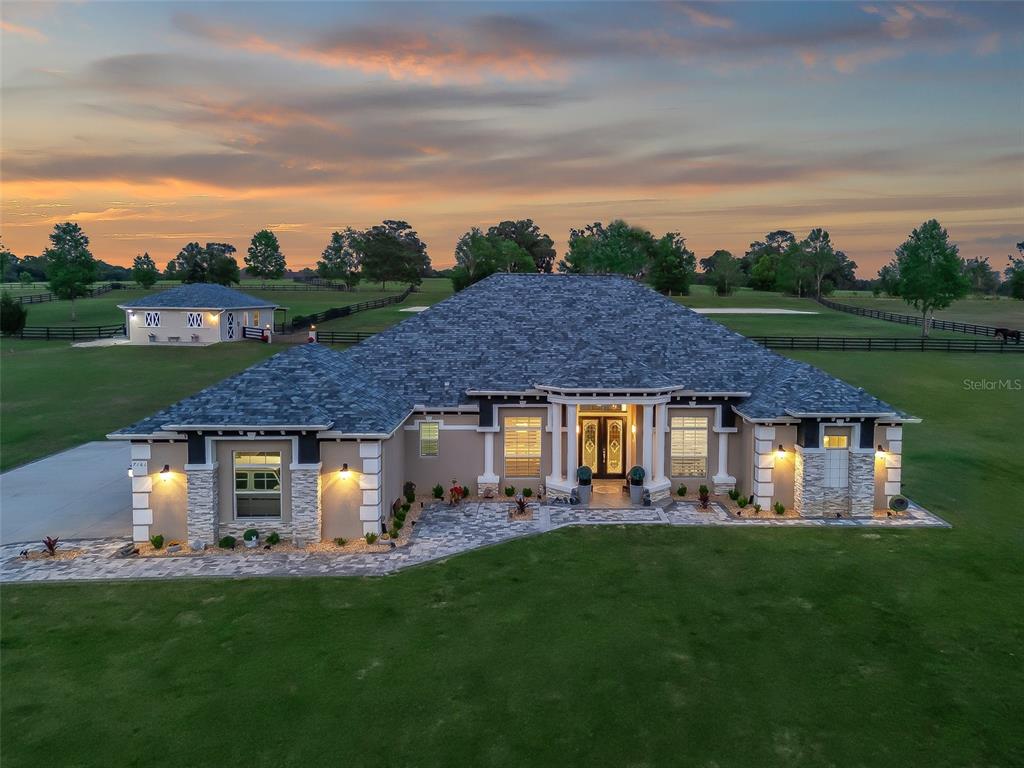 An aerial view of a single-story house with a stone facade and a gray roof — 7161 NE 22ND COURT ROAD, OCALA, FL