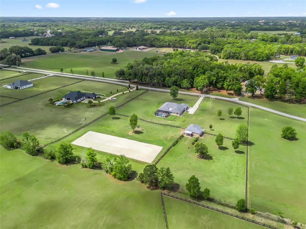 An aerial view shows a rural property with a house, outbuilding, and fenced pasture — 7161 NE 22ND COURT ROAD, OCALA, FL