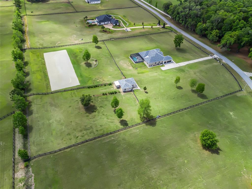 An aerial view shows a large rural property with a house, outbuilding, and fenced pastures — 7161 NE 22ND COURT ROAD, OCALA, FL