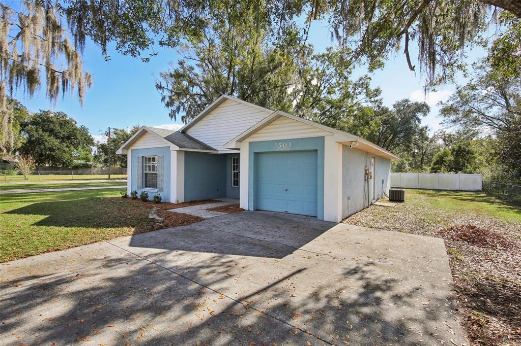 A single-story blue house with a white-trimmed window and a small attached garage — 3501 W REYNOLDS STREET, PLANT CITY, FL