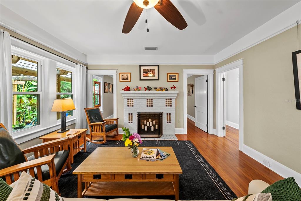 A living room features a white brick fireplace, hardwood floors, and a wooden coffee table — 2915 W ANGELES STREET, TAMPA, FL