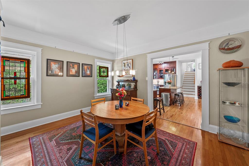 A dining room with a round wooden table, area rug, and view into the kitchen — 2915 W ANGELES STREET, TAMPA, FL