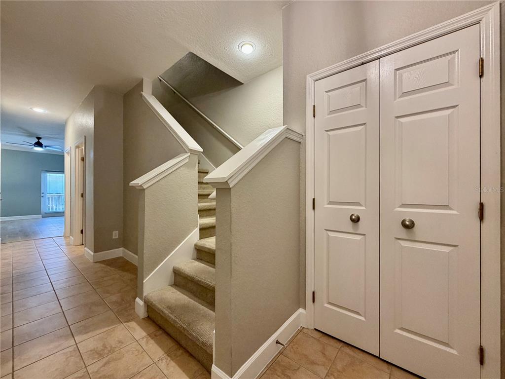 A carpeted staircase with white railings sits beside a white double-door closet in a hallway — 526 101ST AVENUE N, ST PETERSBURG, FL