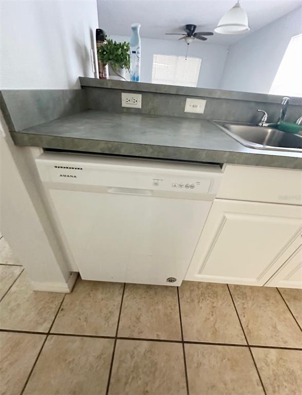 A white Amana dishwasher is installed under a gray countertop next to a kitchen sink — 2306 SW 42ND DRIVE UNIT 140, GAINESVILLE, FL