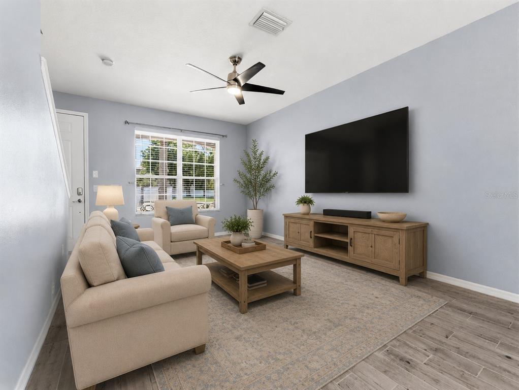 A living room features a beige sofa, armchair, wooden coffee table, and a wall-mounted television — 11513 DECLARATION DRIVE, TAMPA, FL