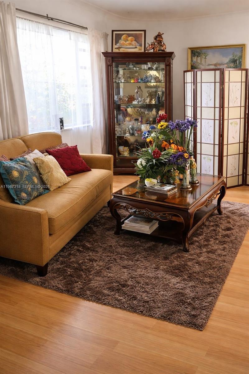 A living room features a tan sofa, a wooden coffee table, and a glass display cabinet — 13108 SW 3rd St, Miami FL 33184, MIAMI, FL