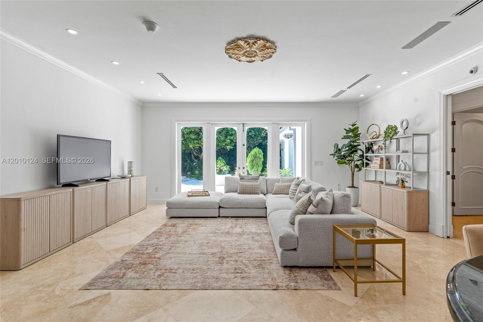 A living room features a large sectional sofa, a television console, and glass doors — 9400 Old Cutler Rd, Coral Gables FL 33156, CORAL GABLES, FL