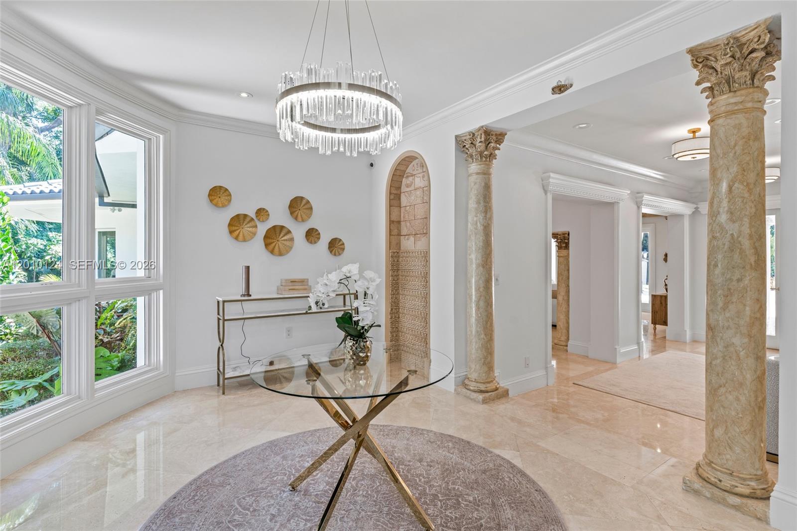 A bright foyer features marble floors, a glass table, and decorative columns under a chandelier — 9400 Old Cutler Rd, Coral Gables FL 33156, CORAL GABLES, FL