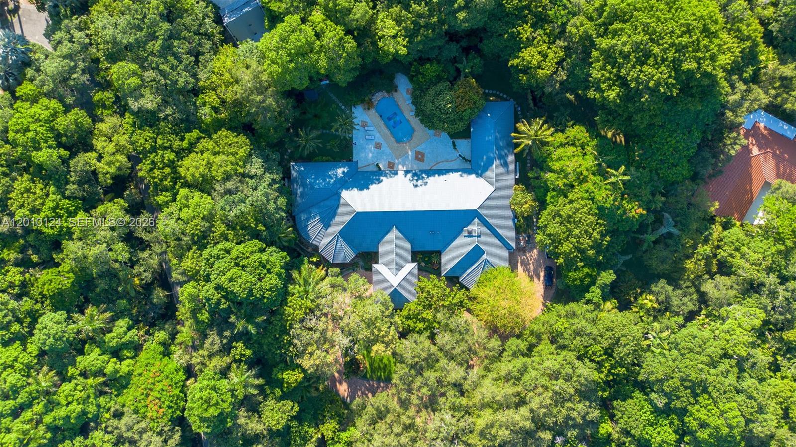 An aerial view shows a large house with a blue roof surrounded by dense trees — 9400 Old Cutler Rd, Coral Gables FL 33156, CORAL GABLES, FL