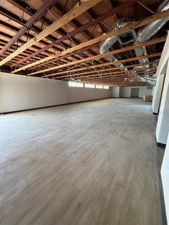 An unfinished commercial space features exposed wooden ceiling joists, ductwork, and light-colored wood-look flooring — 109 W BRIDGERS AVENUE, AUBURNDALE, FL