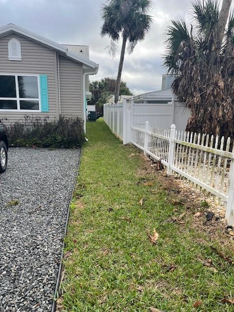 A side yard features a gravel driveway, a grassy strip, and a white picket fence — 1907 S DAYTONA AVENUE, FLAGLER BEACH, FL