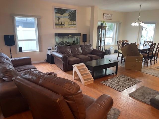 A living room with brown leather furniture, a fish tank, and a dining area beyond — 1907 S DAYTONA AVENUE, FLAGLER BEACH, FL